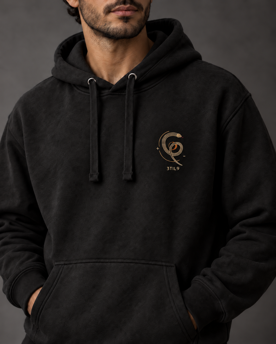 Serpent Orbit Hoodie - Black, model view with the selected coil, crescent and separate 3TIL9 embroidery; digital illustration.