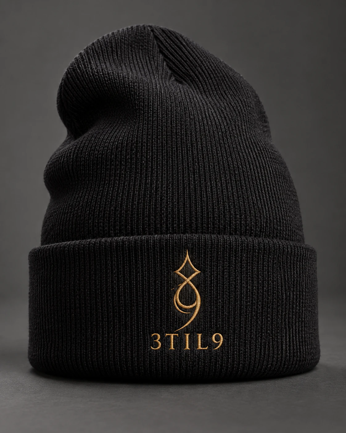 3TIL9 Sigil — black beanie with small embroidery and 3TIL9 logo; AI concept mockup, not a manufactured sample