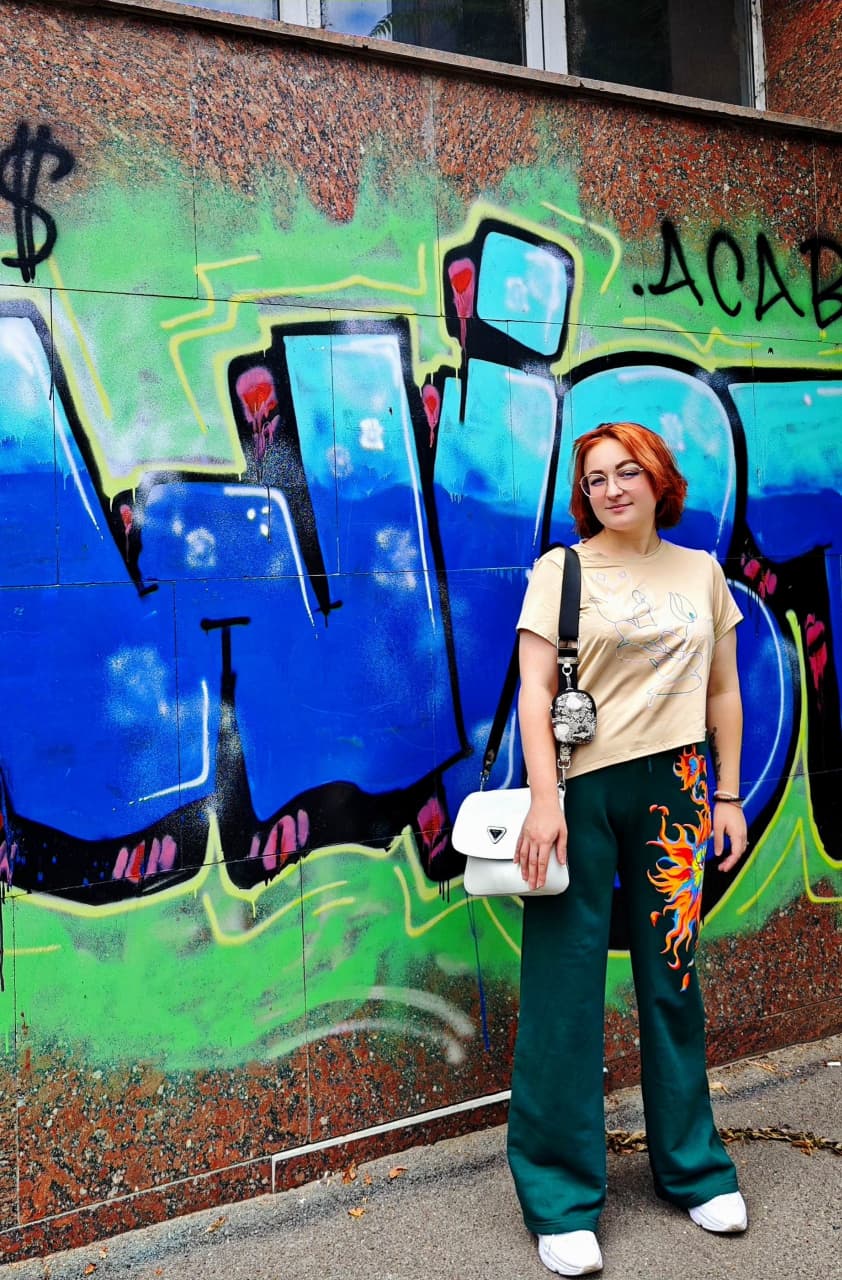 SkvozTmu wearing the brush-painted green Flame Eye trousers in 2023.